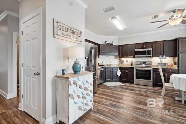 kitchen featuring visible vents, ornamental molding, appliances with stainless steel finishes, dark brown cabinetry, and a sink