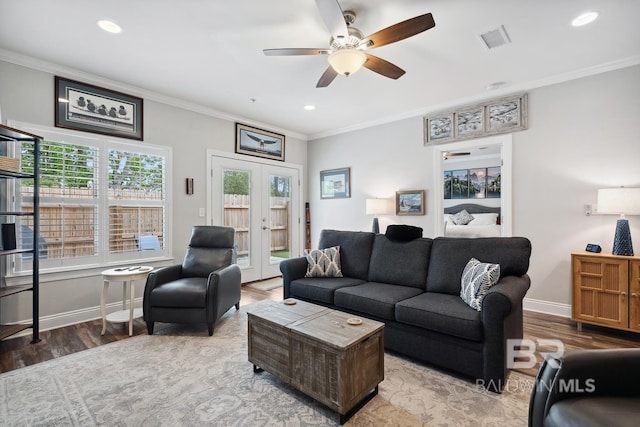 living area featuring crown molding, french doors, baseboards, visible vents, and wood finished floors