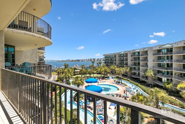 balcony featuring a water view and a community pool