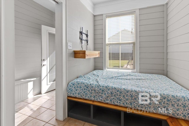 tiled bedroom featuring wooden walls