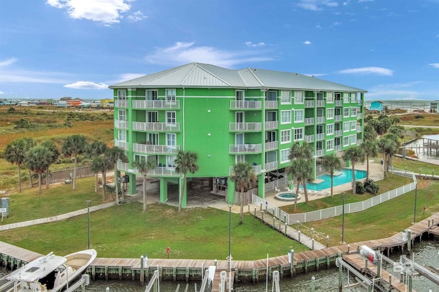 view of building exterior featuring a water view and a community pool