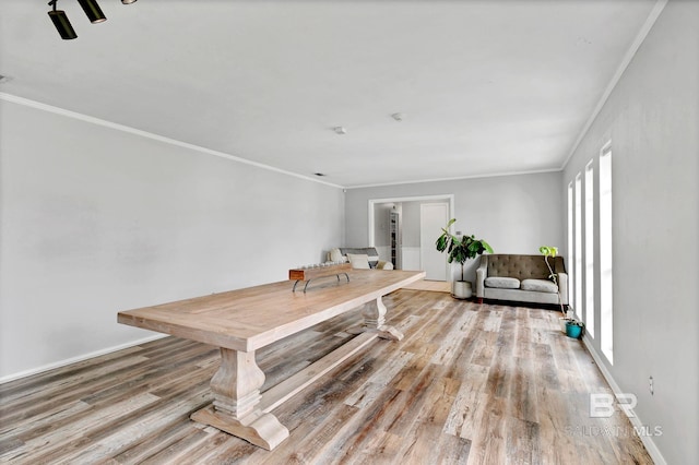 dining room with baseboards, ornamental molding, and wood finished floors