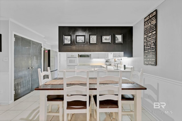 dining room with ornamental molding and light tile patterned floors