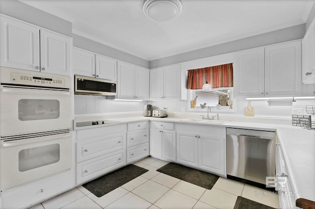 kitchen featuring appliances with stainless steel finishes, light countertops, white cabinets, and a sink