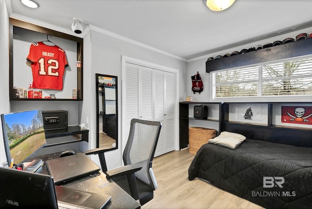 bedroom featuring ornamental molding, a closet, and wood finished floors