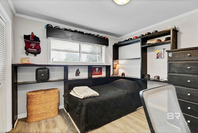 bedroom with ornamental molding and wood finished floors