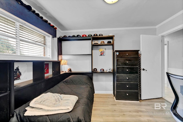 bedroom with ornamental molding and wood finished floors