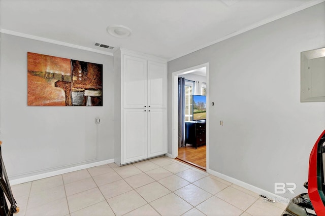 interior space with visible vents, light tile patterned floors, electric panel, and crown molding