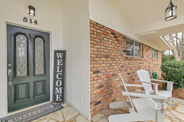 view of exterior entry featuring brick siding