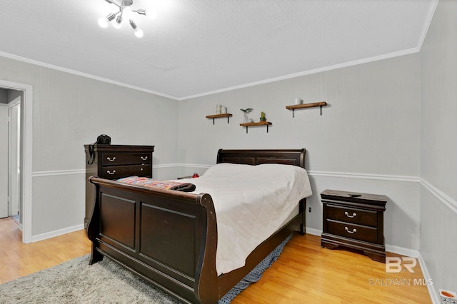 bedroom with light wood-type flooring, baseboards, and crown molding