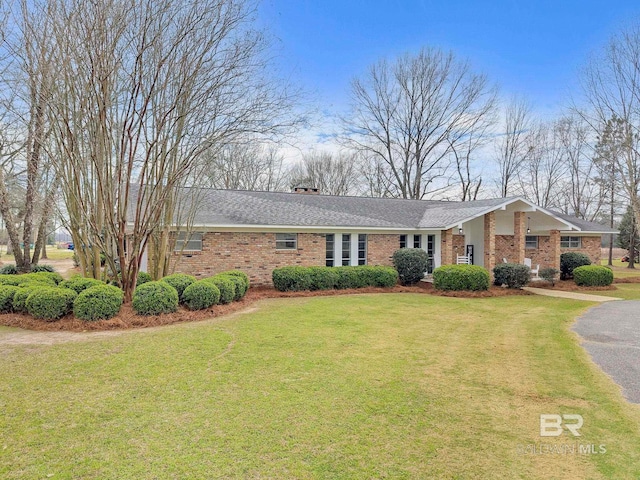 view of front of home with a front yard and brick siding