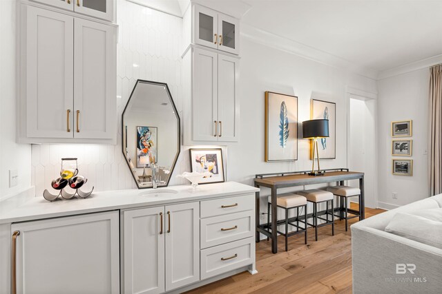452 Colony Dr, Fairhope, AL 36532 - bar with baseboards, crown molding, a sink, and light wood finished floors