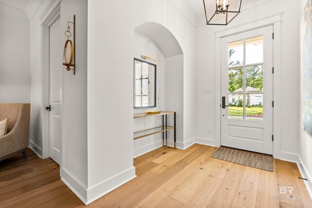 452 Colony Dr, Fairhope, AL 36532 - entrance foyer featuring light wood-style flooring, baseboards, arched walkways, and a notable chandelier