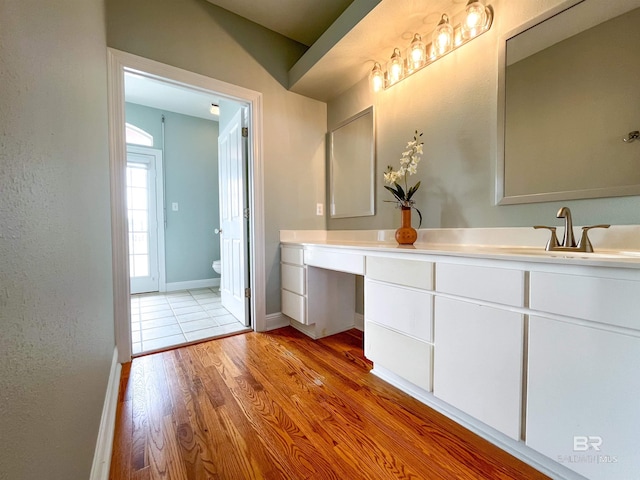 2210 W Beach Blvd, Gulf Shores, AL 36542 - bathroom featuring baseboards, wood finished floors, toilet, and vanity