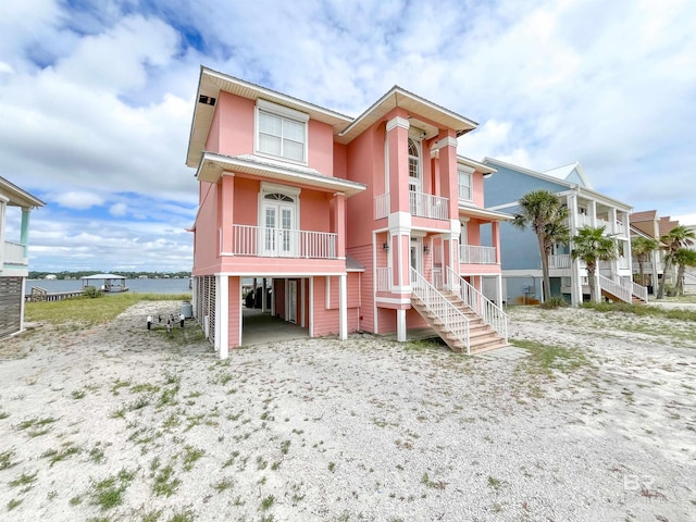2210 W Beach Blvd, Gulf Shores, AL 36542 - view of front of property with stucco siding, driveway, a carport, and stairs