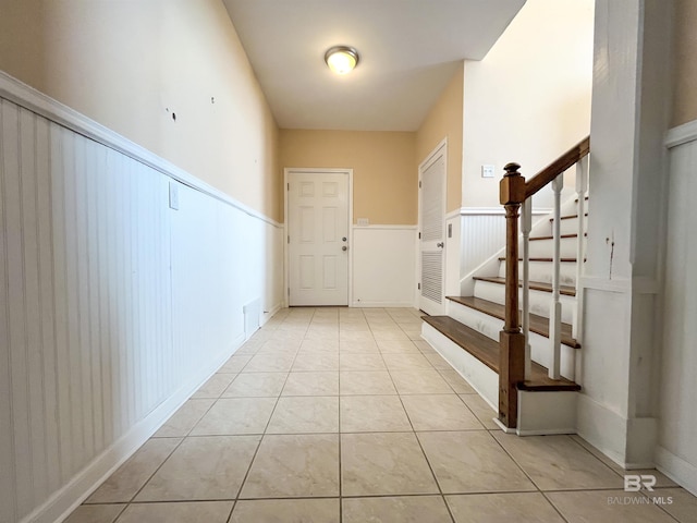 2210 W Beach Blvd, Gulf Shores, AL 36542 - entrance foyer featuring stairs, light tile patterned floors, and wainscoting
