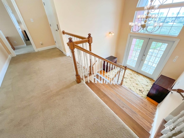 2210 W Beach Blvd, Gulf Shores, AL 36542 - stairway with carpet, baseboards, a towering ceiling, an inviting chandelier, and french doors