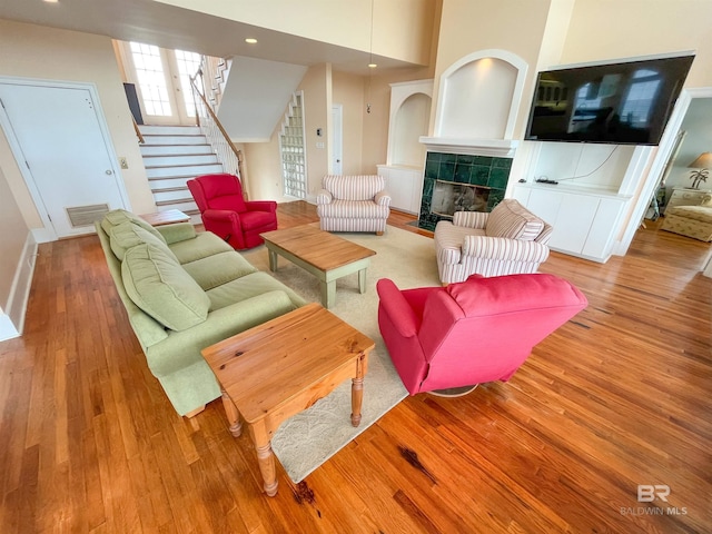 2210 W Beach Blvd, Gulf Shores, AL 36542 - living area featuring a tiled fireplace, visible vents, stairway, and wood finished floors