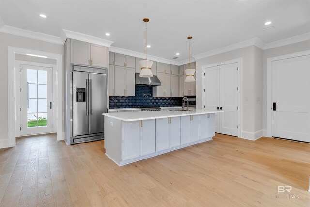926 Inlet Cir, Gulf Shores, AL 36542 - kitchen featuring built in fridge, light countertops, decorative backsplash, exhaust hood, and light wood-type flooring