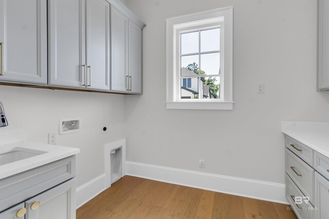 926 Inlet Cir, Gulf Shores, AL 36542 - washroom featuring cabinet space, hookup for a washing machine, light wood-style flooring, and electric dryer hookup