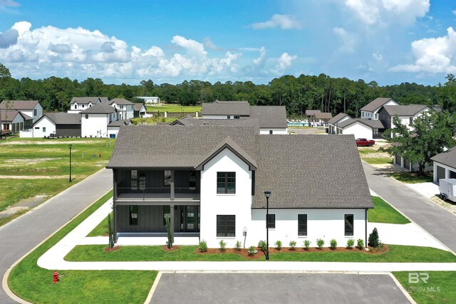 926 Inlet Cir, Gulf Shores, AL 36542 - back of property with a balcony, roof with shingles, a residential view, and a yard