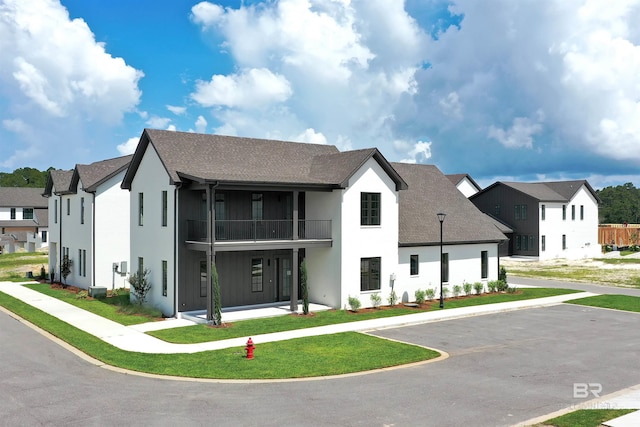 926 Inlet Cir, Gulf Shores, AL 36542 - view of front facade featuring a balcony, stucco siding, a residential view, roof with shingles, and a front yard