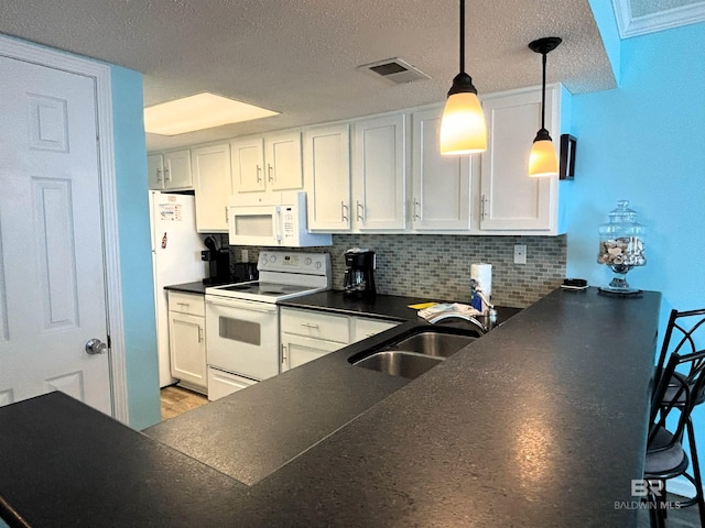 kitchen with tasteful backsplash, white appliances, pendant lighting, white cabinets, and sink