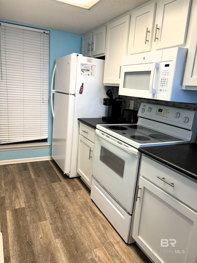 kitchen with white appliances, white cabinets, and hardwood / wood-style flooring