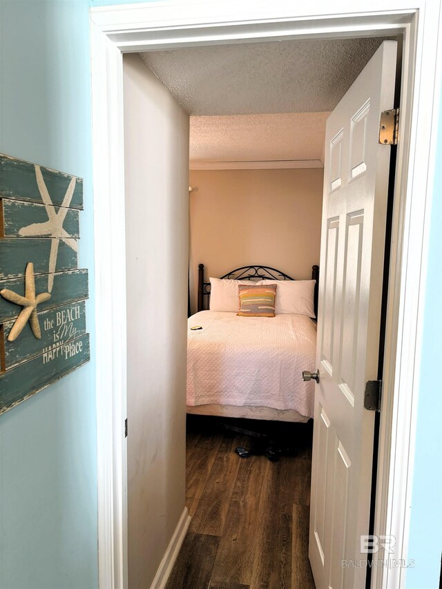 505 E Beach Blvd Unit 5-C, Gulf Shores, AL 36542 - bedroom with crown molding, a textured ceiling, and dark wood-style flooring