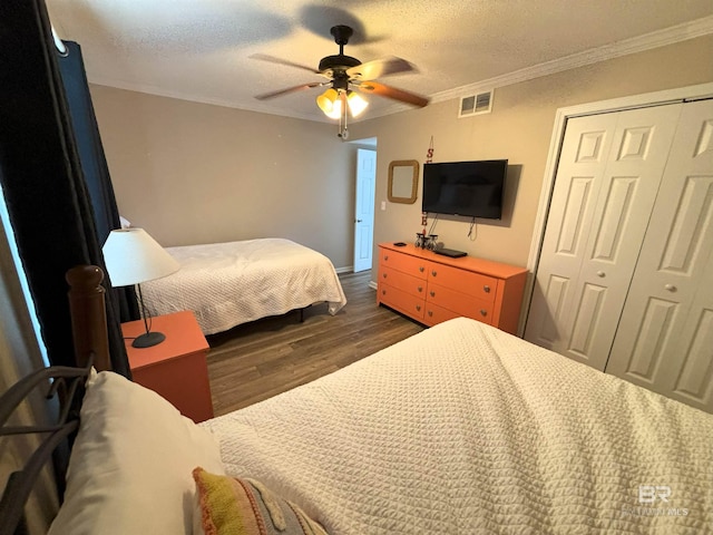 bedroom with a textured ceiling, crown molding, a closet, ceiling fan, and dark hardwood / wood-style floors