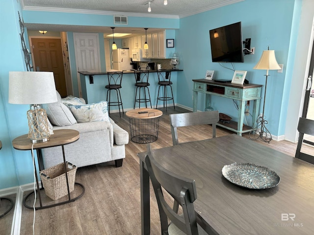 living room featuring a textured ceiling, hardwood / wood-style floors, and crown molding