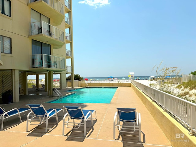 view of pool with a patio and a water view