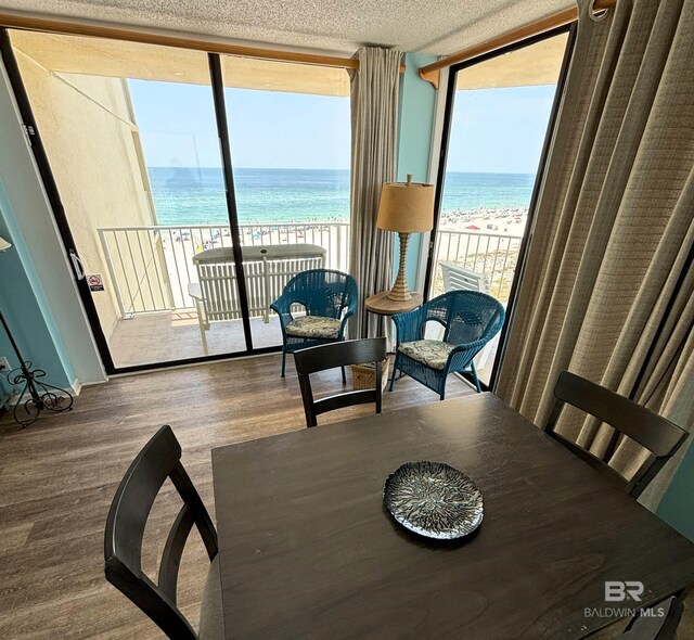 505 E Beach Blvd Unit 5-C, Gulf Shores, AL 36542 - dining space with a beach view, wood finished floors, a water view, and expansive windows