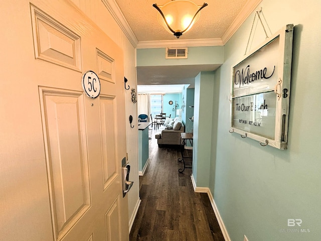 hall featuring a textured ceiling, ornamental molding, and dark hardwood / wood-style floors