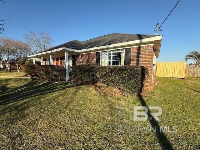 ranch-style home featuring fence, a front lawn, and brick siding