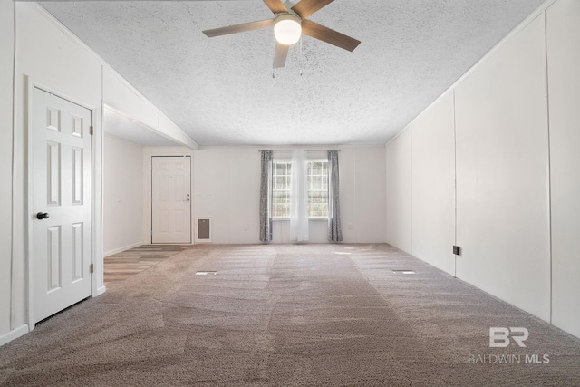 spare room with ceiling fan, a textured ceiling, visible vents, and carpet flooring