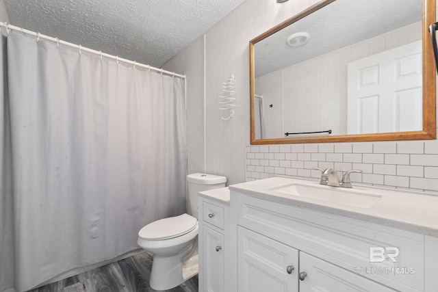 full bath with decorative backsplash, toilet, a textured ceiling, vanity, and wood finished floors