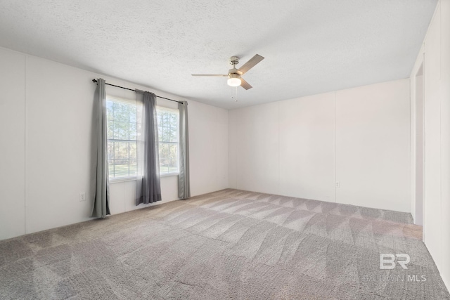 carpeted empty room with a textured ceiling and ceiling fan