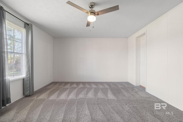 unfurnished room featuring carpet floors, ceiling fan, and a textured ceiling