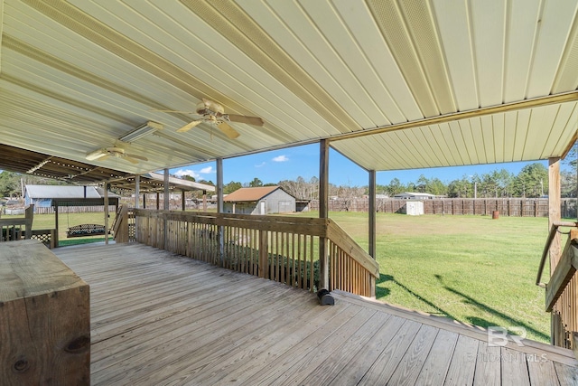 wooden deck with a storage shed, ceiling fan, fence, a yard, and an outdoor structure