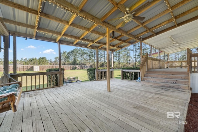 wooden deck featuring ceiling fan, a yard, and fence