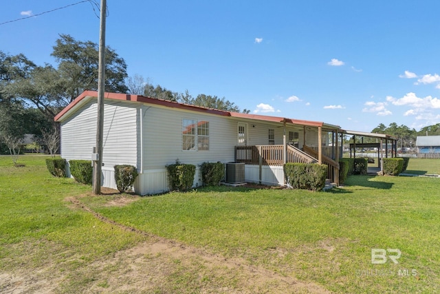 rear view of property with central AC and a lawn