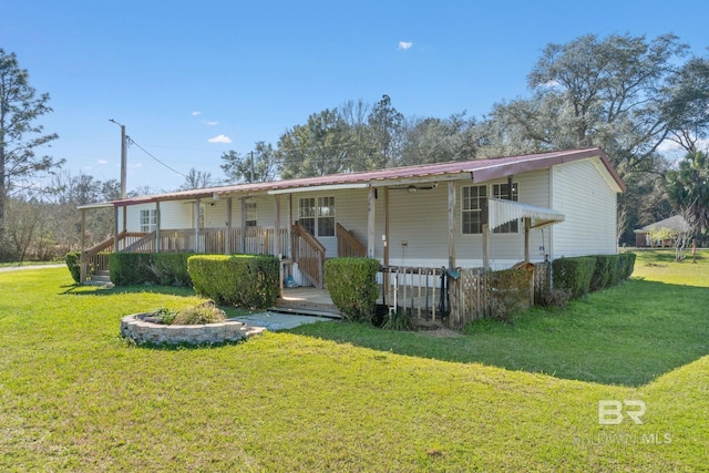 view of front of house featuring covered porch, metal roof, and a front yard