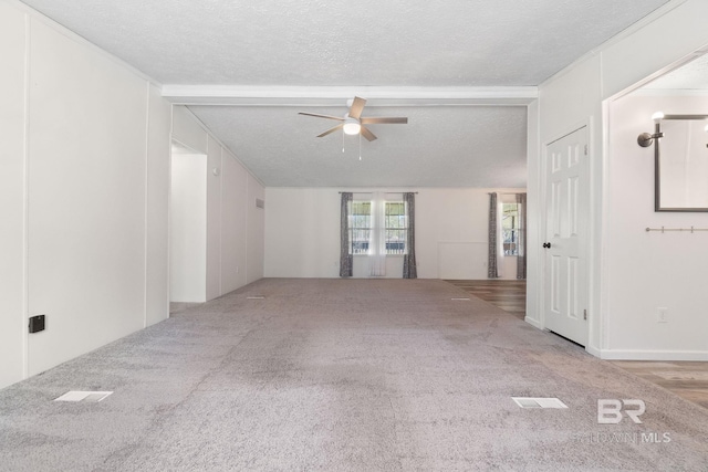 carpeted spare room with a textured ceiling and a ceiling fan