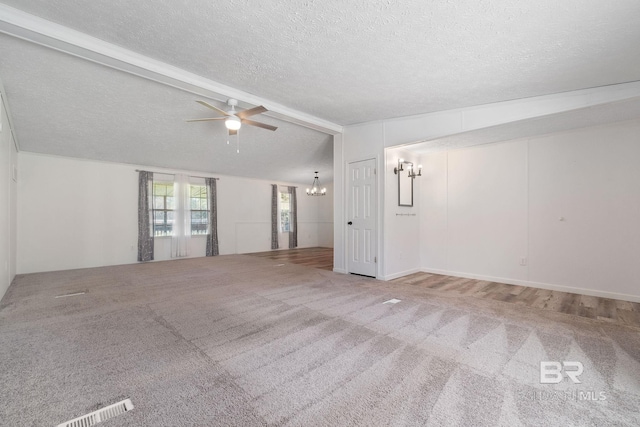 empty room featuring vaulted ceiling with beams, a textured ceiling, ceiling fan with notable chandelier, visible vents, and carpet