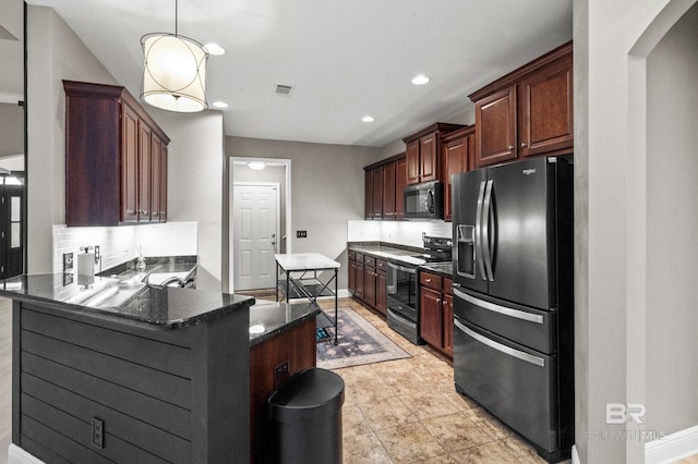 kitchen featuring decorative light fixtures, stainless steel appliances, kitchen peninsula, and tasteful backsplash