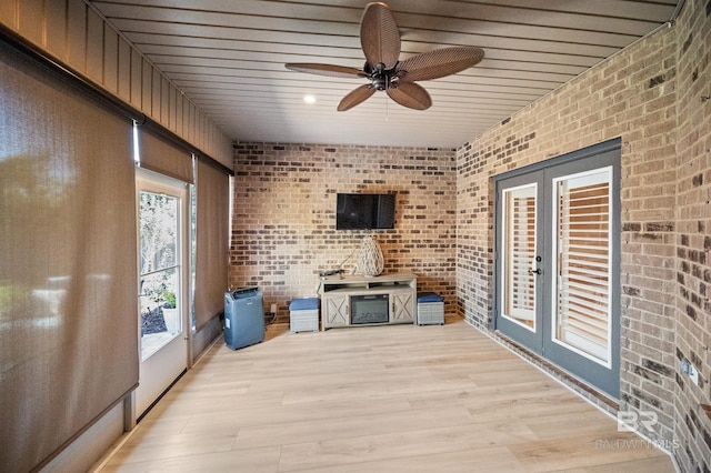 unfurnished sunroom featuring ceiling fan and french doors