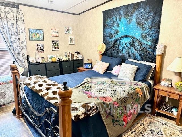 bedroom featuring crown molding and hardwood / wood-style flooring