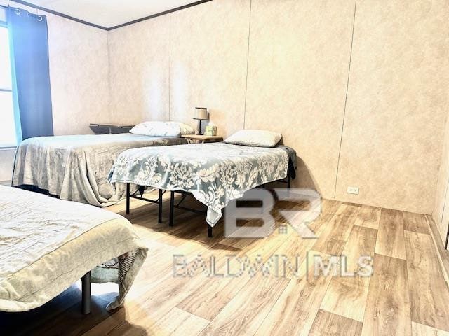 bedroom featuring crown molding and hardwood / wood-style flooring