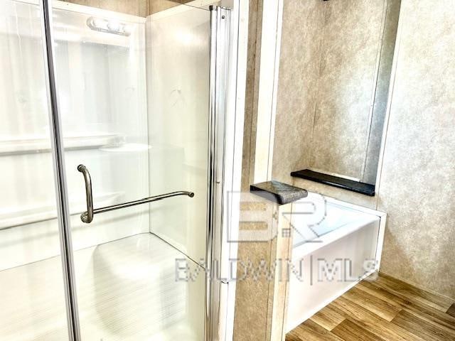 bathroom with hardwood / wood-style floors and walk in shower